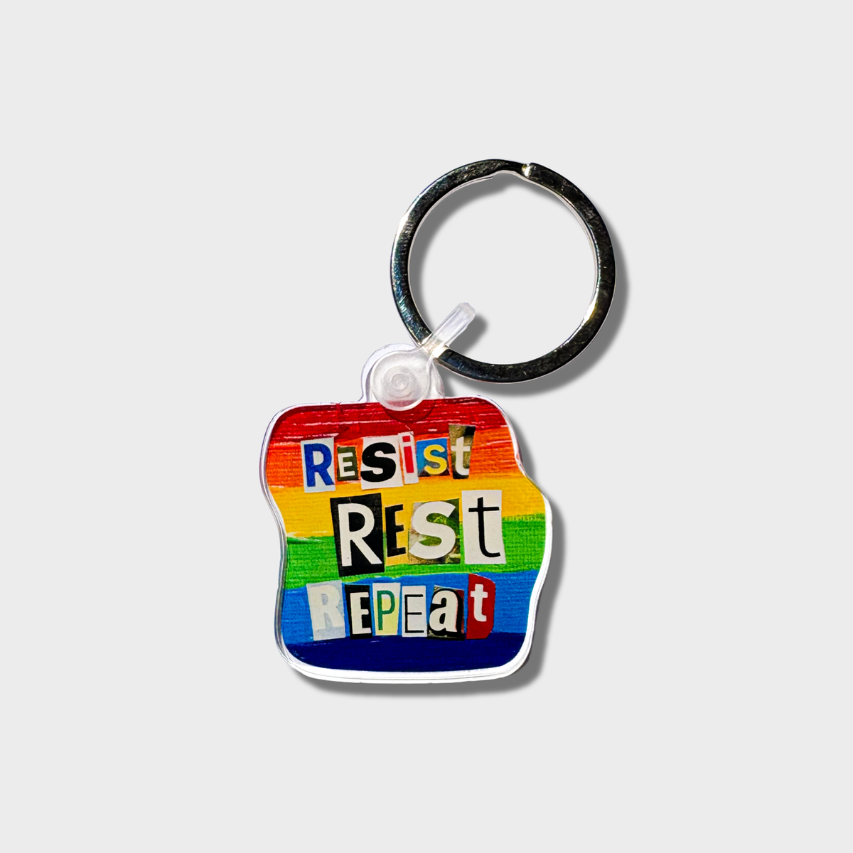 Keychain with 'Resist Rest Repeat' text on a white background
